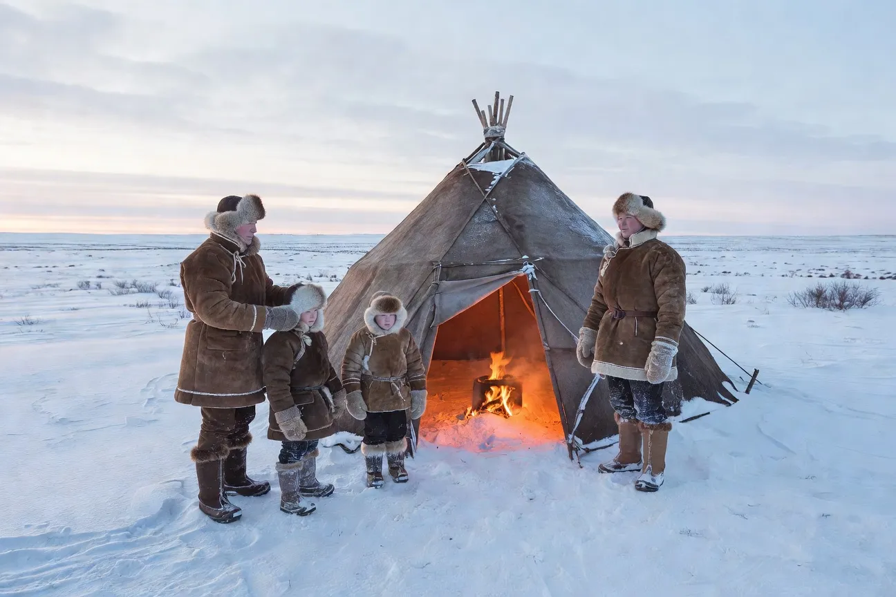 Famille nenets devant son chum traditionnel en peaux de rennes dans la toundra arctique russe